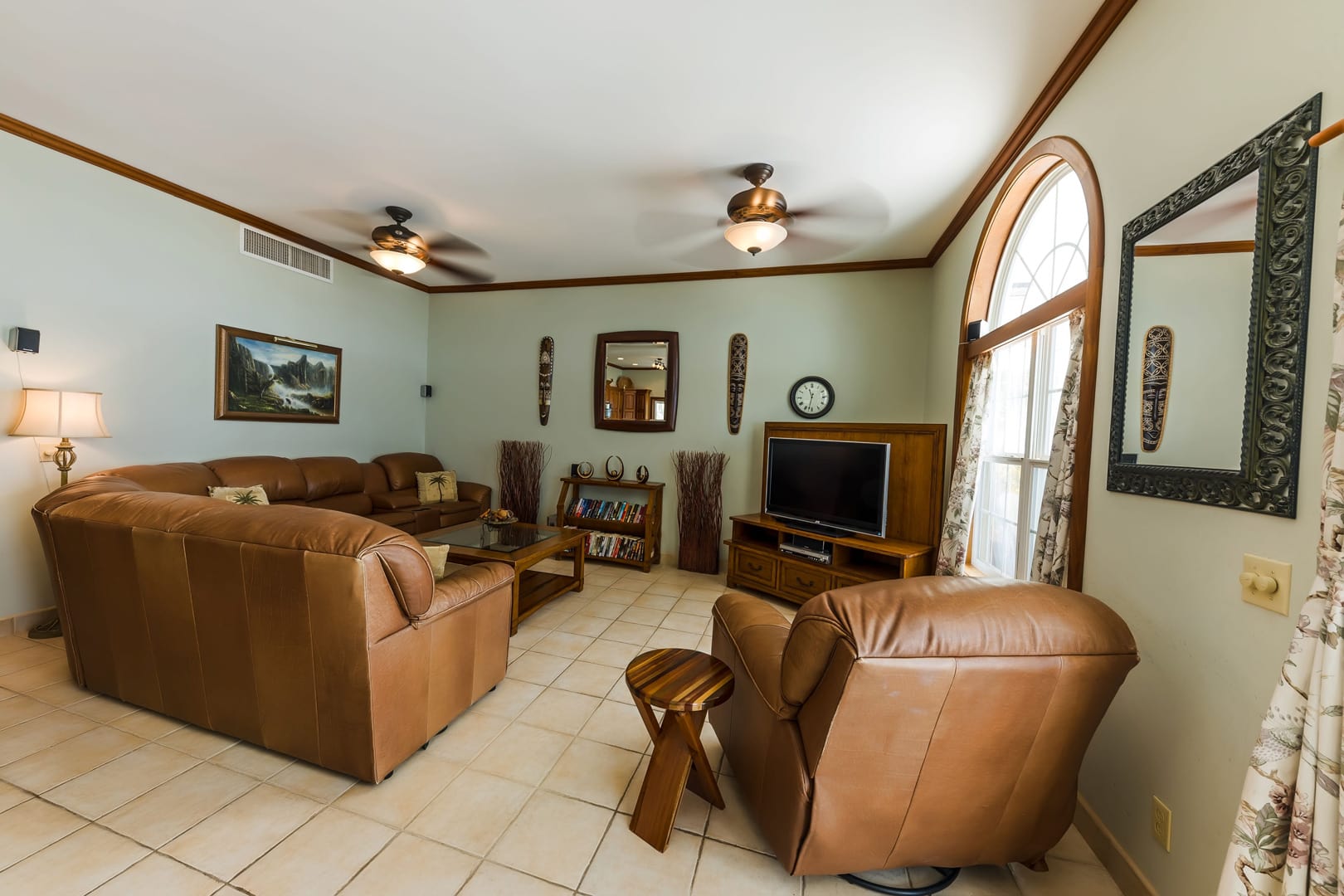 Comfortable and homey living space with tropical-inspired decor, plush seating, and a cozy atmosphere for relaxation and entertainment