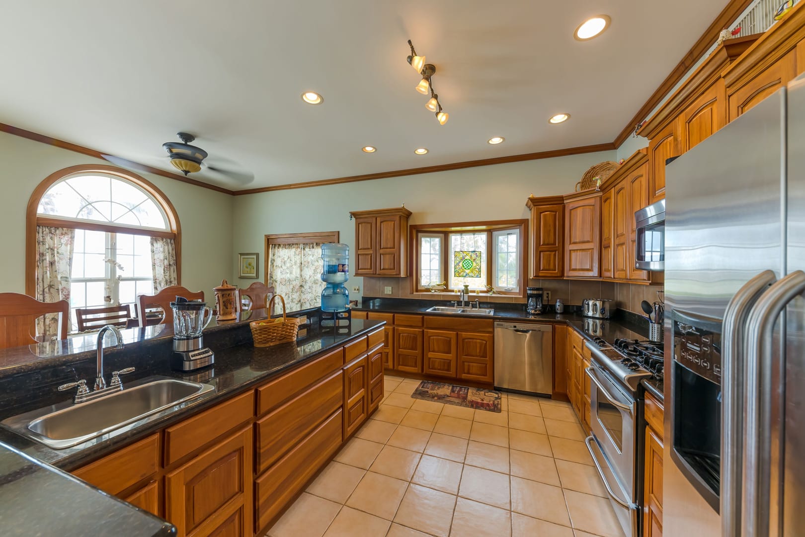 Fully equipped, modern kitchen with sleek appliances, granite countertops, and tropical accents, providing a convenient and functional space for cooking and entertaining.